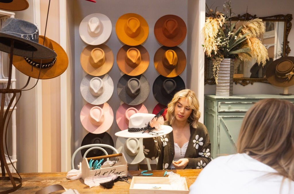 A-customer-working-with-a-stylist-at-a-Flea-Style-hat-bar