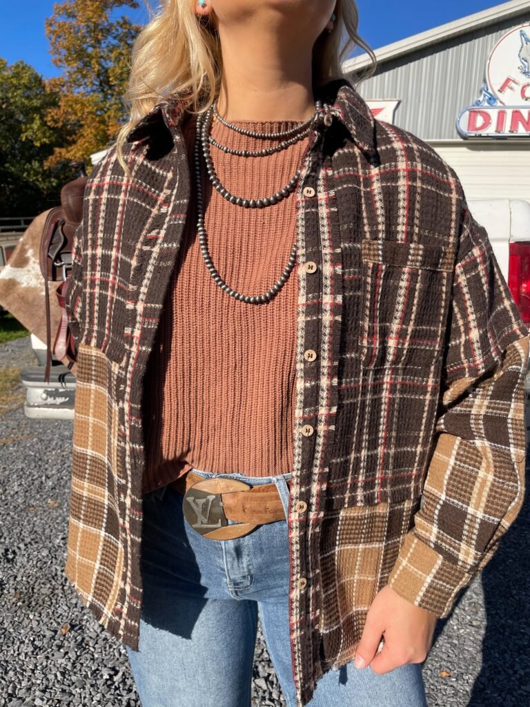 A-flat-lay-featuring-a-plaid-shirt-dress-Navajo-pearls-and-brown-leather-cowboy-boots